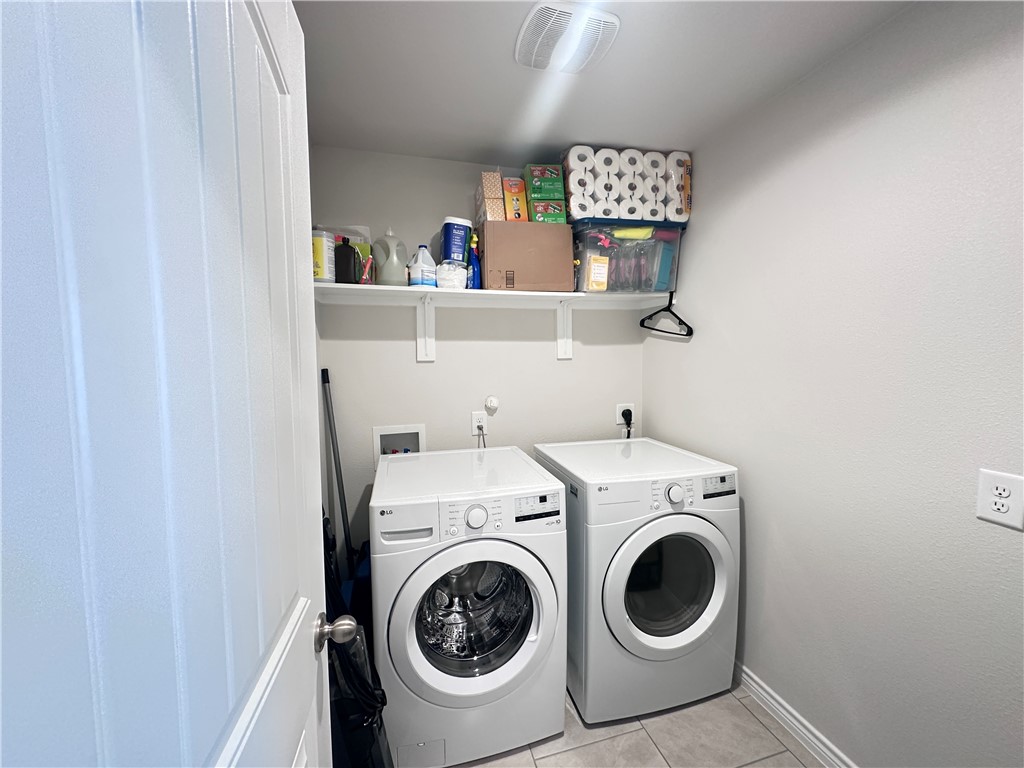 7649 Herd Rider Lane Corpus Christi, TX 78414 - Photo 17 of 18 a view of washer and dryer with kitchen in the background