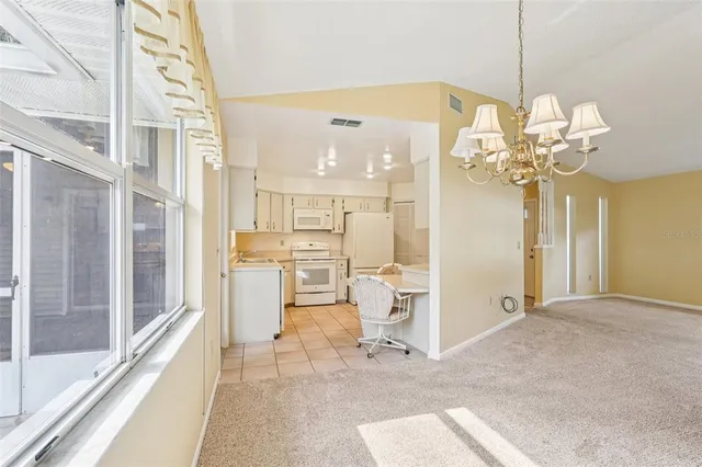 a view of a chandelier fan and refrigerator