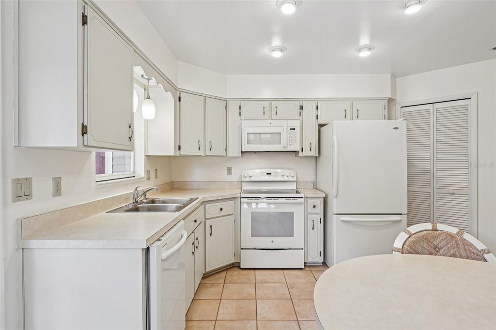305 Brigadoon Circle Leesburg, FL 34788 - Photo 17 of 38 a kitchen with a sink a stove a refrigerator and white cabinets