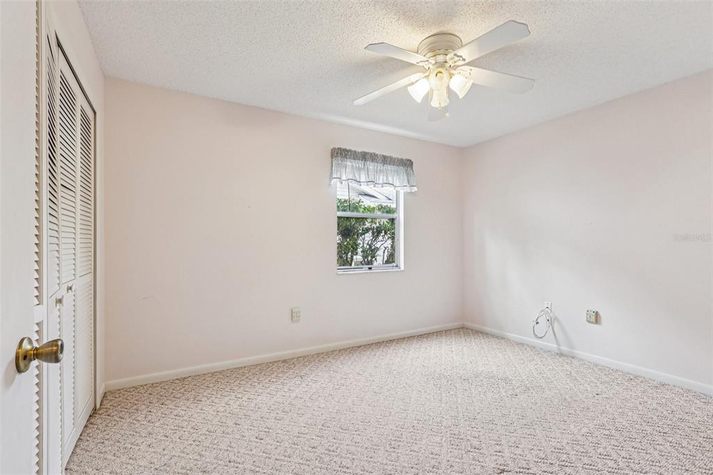 305 Brigadoon Circle Leesburg, FL 34788 - Photo 20 of 38 an empty room with windows and fan chandelier fan