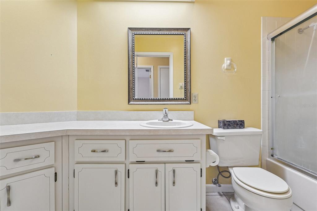 305 Brigadoon Circle Leesburg, FL 34788 - Photo 22 of 38 a bathroom with a granite countertop toilet sink and mirror
