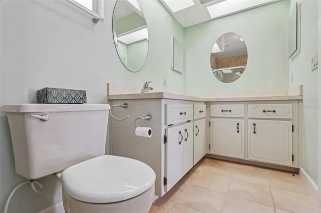a bathroom with a granite countertop toilet sink and mirror
