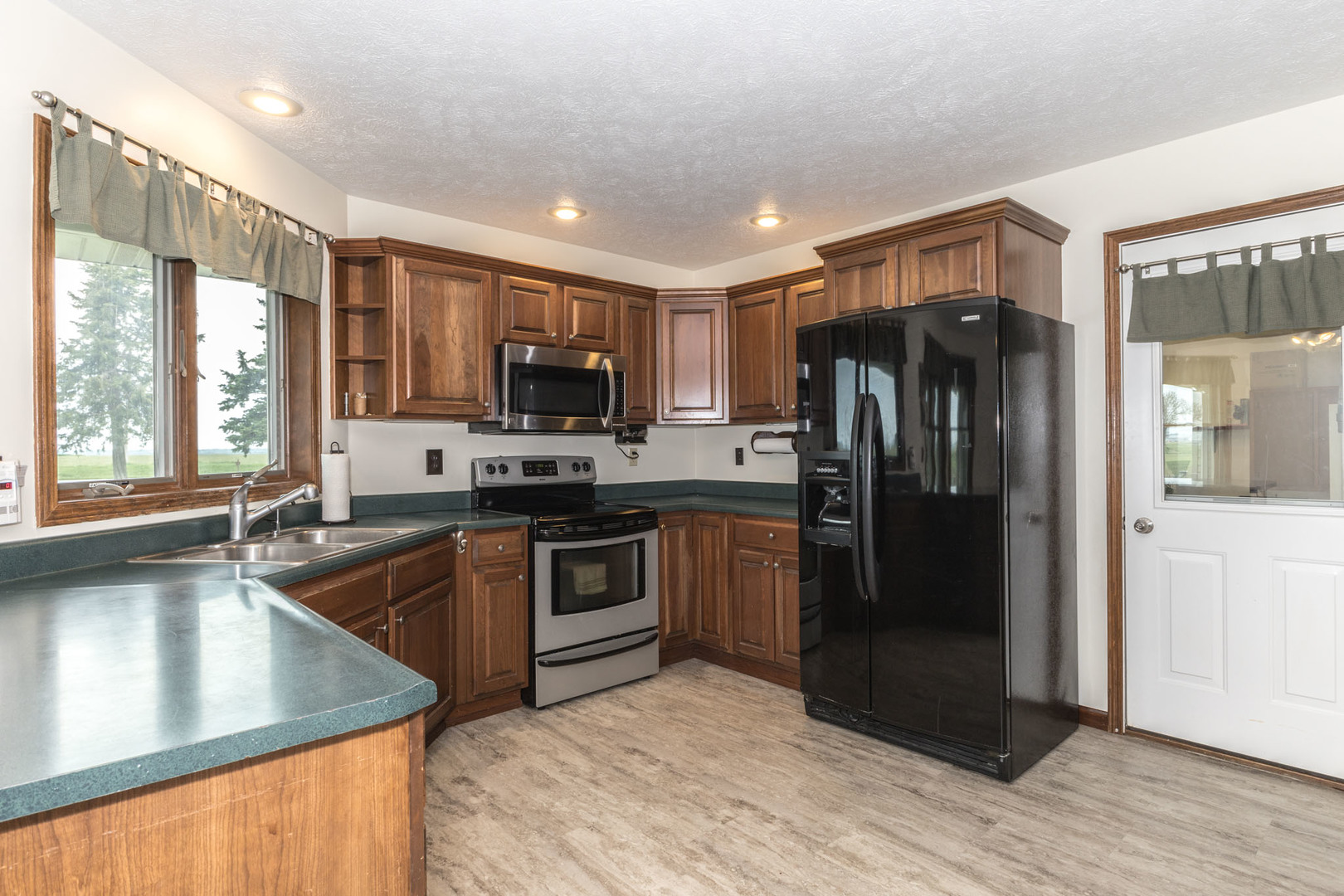 9375 East 3000 N Road Cornell, IL 61319 - Photo 16 of 39 a kitchen with kitchen island granite countertop a refrigerator stove and sink