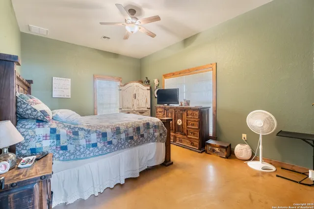 a spacious bedroom with a bed and a chandelier