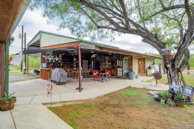 a view of a backyard with table and chairs under an umbrella