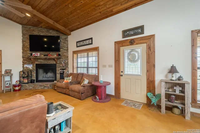 a living room with furniture a fireplace and a flat screen tv