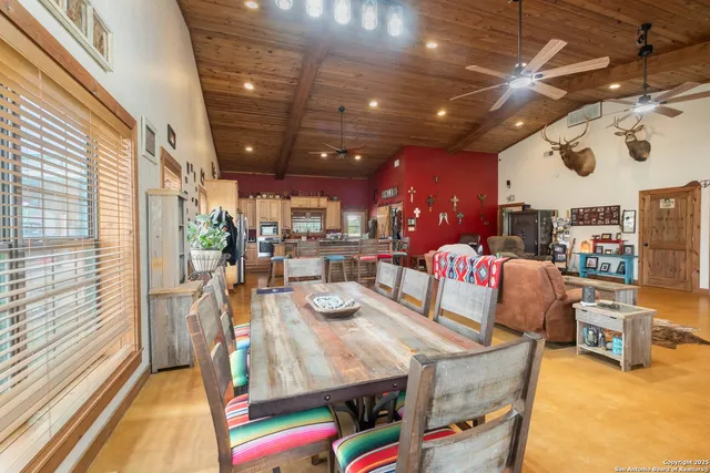 a dining room with furniture and a floor to ceiling window
