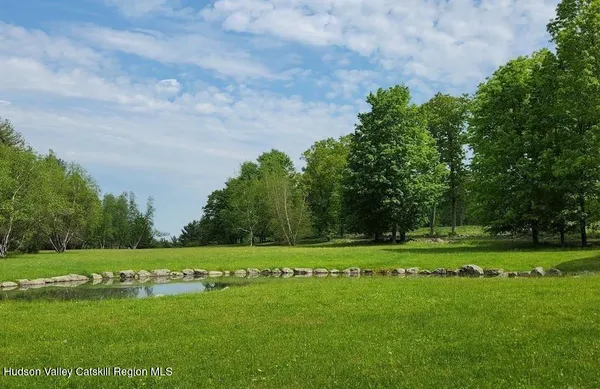 a yard with lots of green space and trees