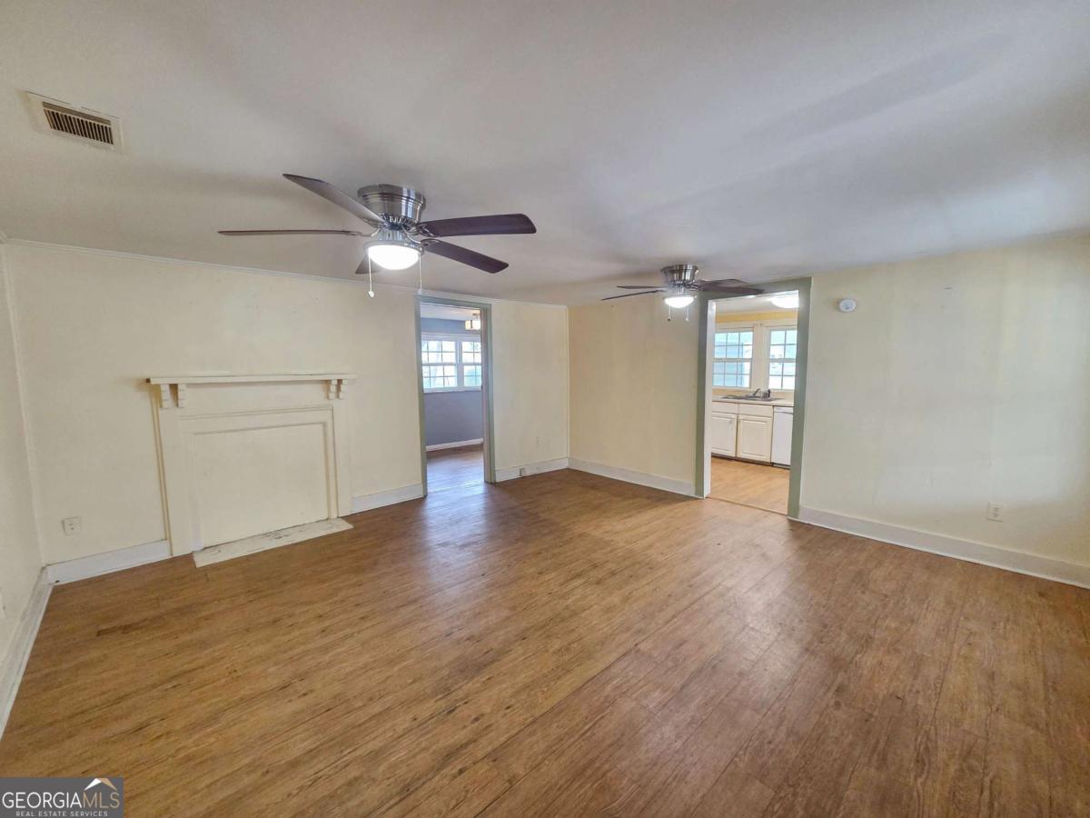 188 Holmesville Road Baxley, GA 31513 - Photo 2 of 20 a view of an empty room with window and wooden floor