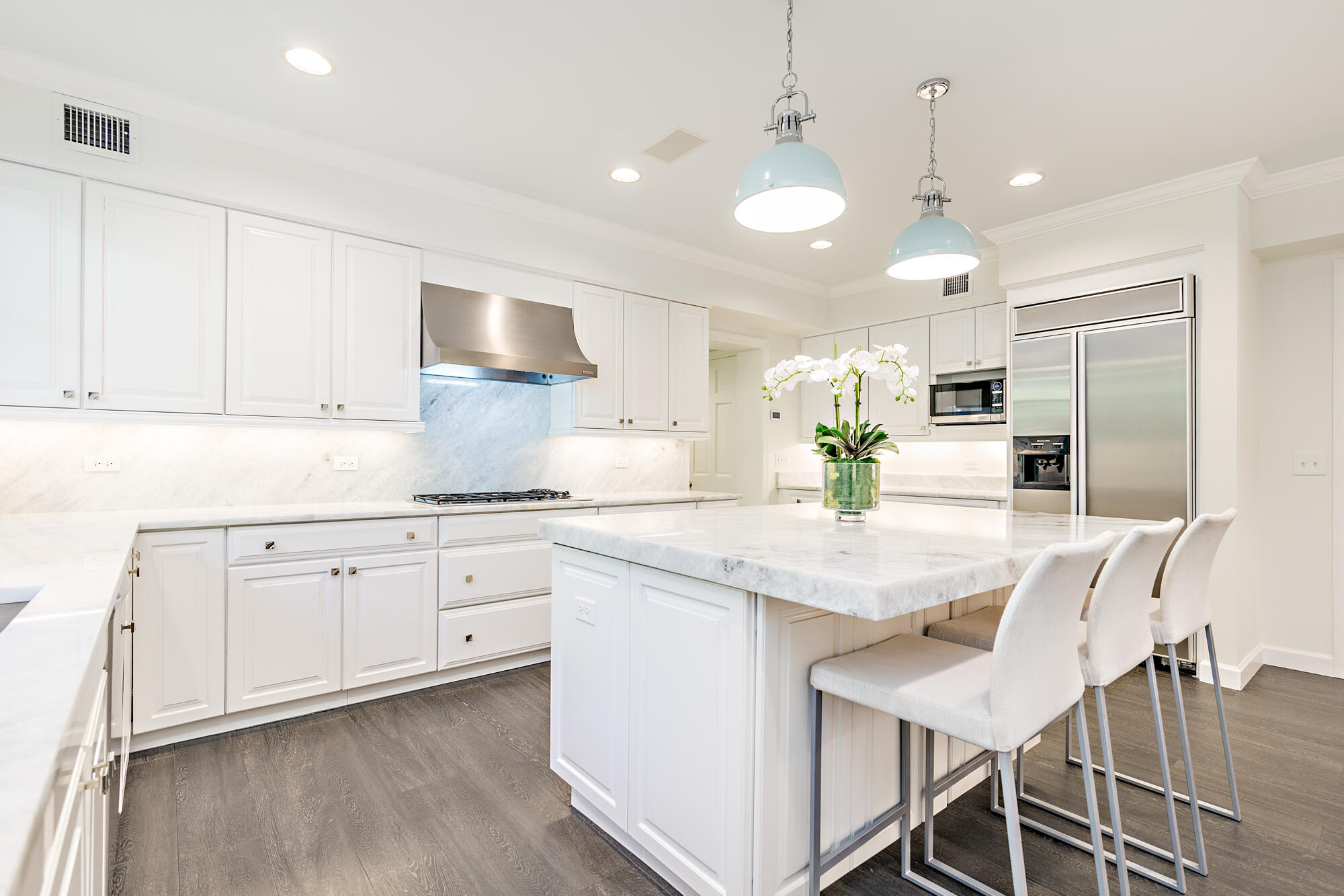 239 Emerald Lane Palm Beach, FL 33480 - Photo 25 of 29 a kitchen with stainless steel appliances kitchen island granite countertop a dining table chairs and white cabinets