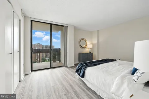 a bedroom with a bed and glass door