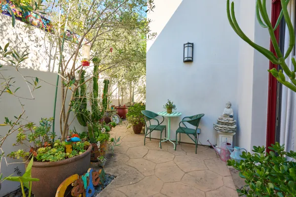 a view of a chair and table in a back yard of the house