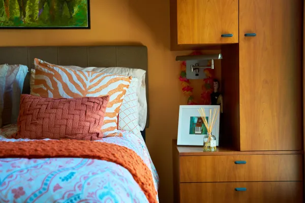 a bedroom with a bed and painting on the wall