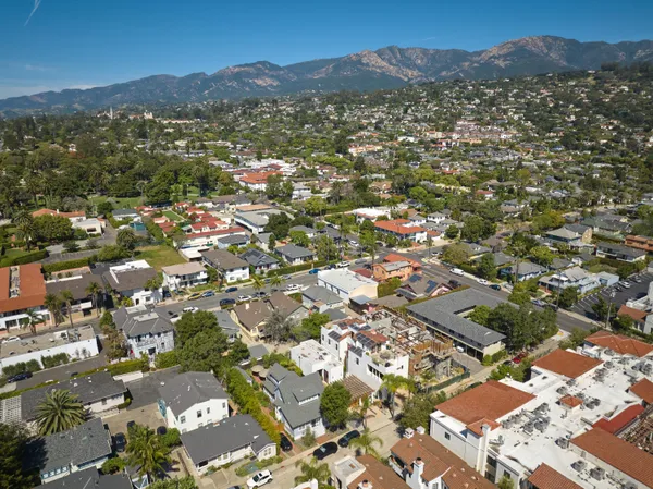 an aerial view of residential houses with outdoor space and trees