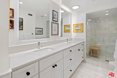 a bathroom with double sink and a mirror