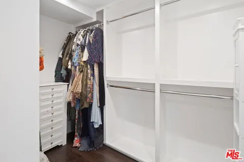 a view of walk in closet with clothes