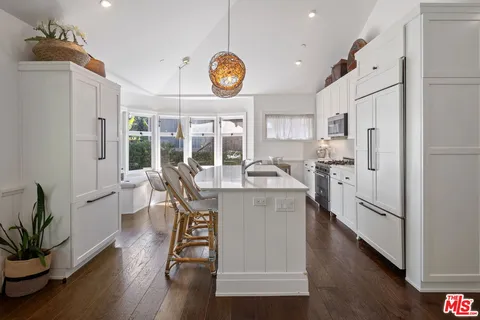 a kitchen with cabinets and wooden floor