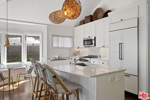 a kitchen with stainless steel appliances granite countertop a sink a stove and a refrigerator