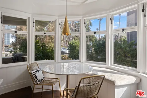 a view of a dining room with furniture large windows and wooden floor