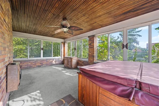 a view of a room with large windows and wooden roof