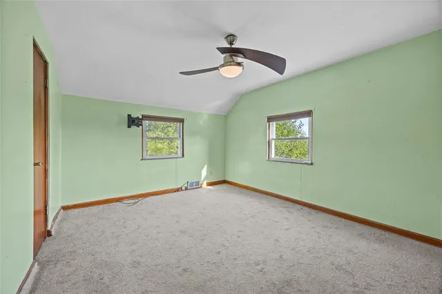 an empty room with a window and a ceiling fan