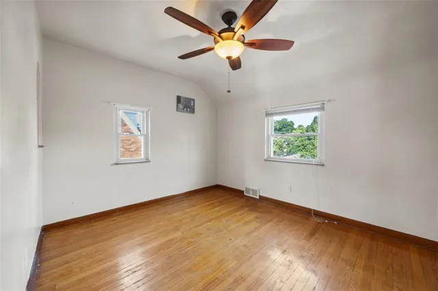 an empty room with a window and a fan