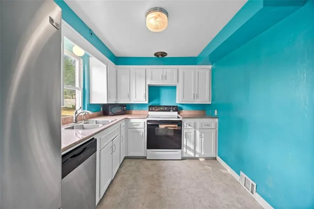 a kitchen with granite countertop a stove sink and cabinets