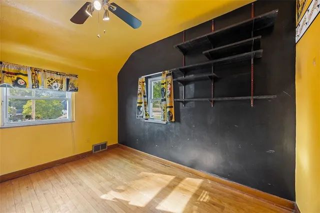 a view of a room with wooden floor and windows