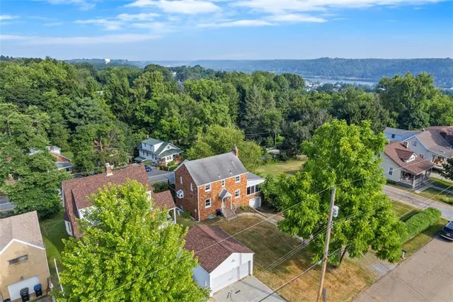 an aerial view of a house with garden space and street view