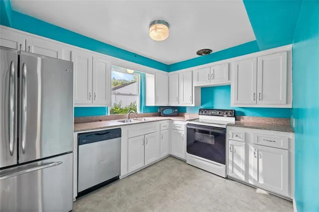 a kitchen with granite countertop a sink stove and refrigerator