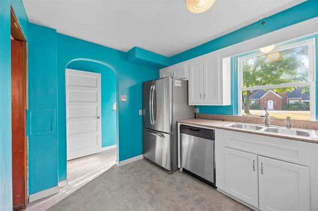 a kitchen with stainless steel appliances granite countertop a refrigerator and a sink
