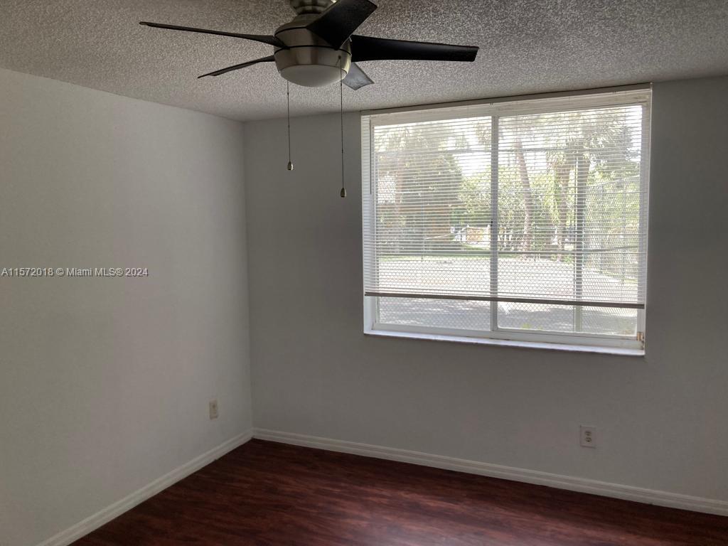 3985 West McNab Road, Unit A111 Pompano Beach, FL 33069 - Photo 12 of 36 a view of empty room with wooden floor and fan