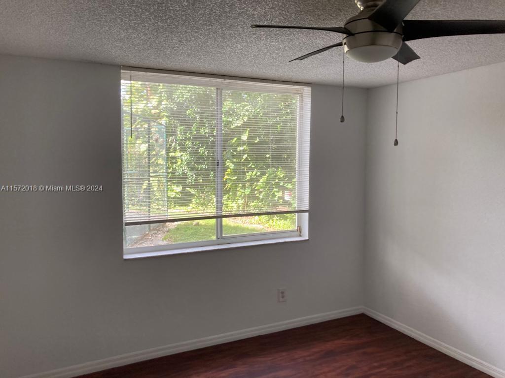 3985 West McNab Road, Unit A111 Pompano Beach, FL 33069 - Photo 17 of 36 a view of empty room with wooden floor and fan