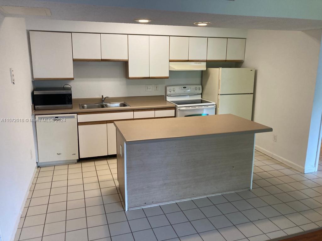 3985 West McNab Road, Unit A111 Pompano Beach, FL 33069 - Photo 3 of 36 a kitchen with stainless steel appliances a refrigerator sink and cabinets