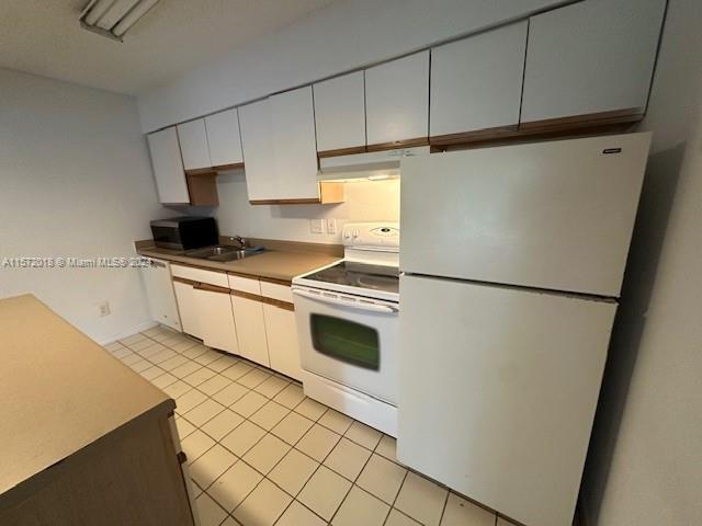 3985 West McNab Road, Unit A111 Pompano Beach, FL 33069 - Photo 34 of 36 a kitchen with stainless steel appliances a refrigerator sink and cabinets