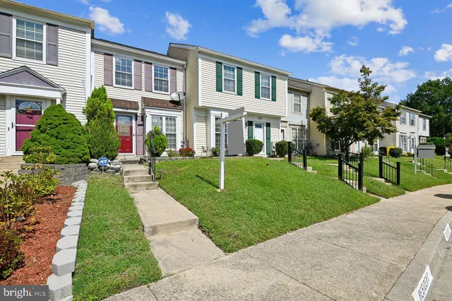 a view of a brick house with a yard garden and plants