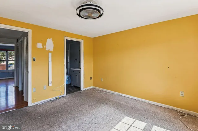 a view of an empty room with window and closet area