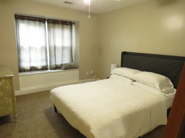 a large bed sitting in a bedroom next to a window