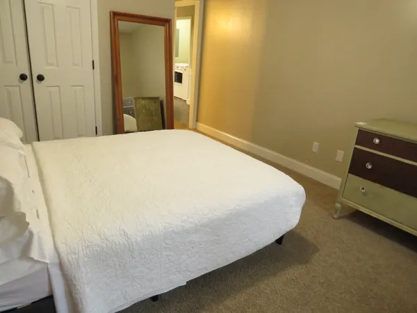 a bed sitting in a bedroom and a mirror