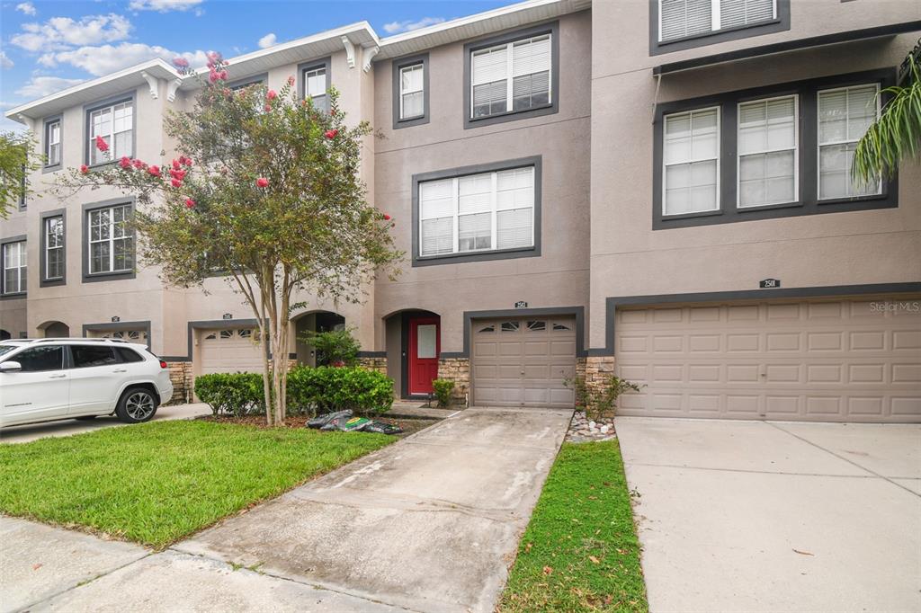 a front view of a house with a garden and trees