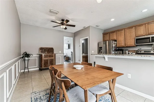 a kitchen with stainless steel appliances granite countertop a kitchen island a stove a sink a dining table and chairs