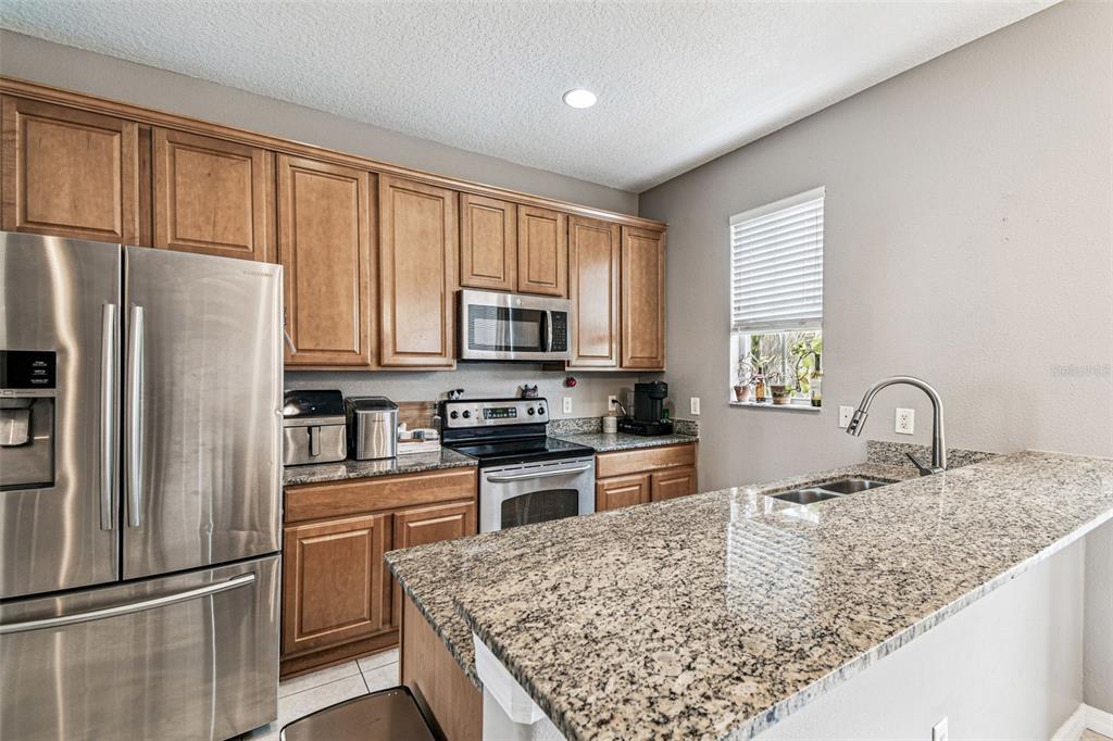2503 Middleton Grove Drive Brandon, FL 33511 - Photo 14 of 39 a kitchen with stainless steel appliances granite countertop a refrigerator stove microwave and sink