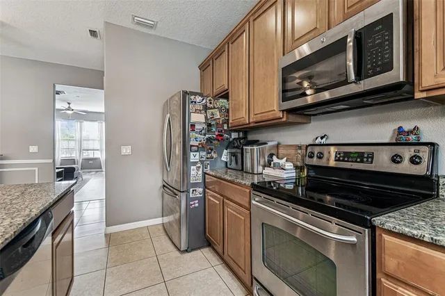 a kitchen with stainless steel appliances granite countertop a stove microwave and refrigerator