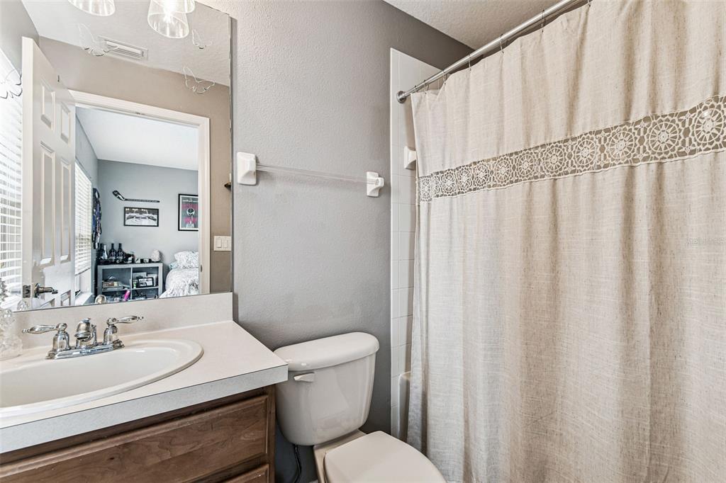 2503 Middleton Grove Drive Brandon, FL 33511 - Photo 25 of 39 a bathroom with a sink a toilet a mirror and shower curtain