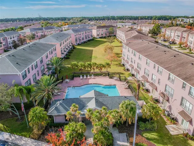 an aerial view of residential houses with outdoor space and swimming pool