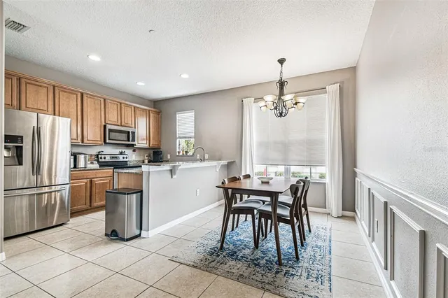 a kitchen with granite countertop cabinets a counter space dining table and stainless steel appliances