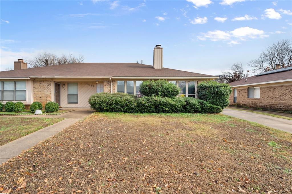 a front view of a house with a yard and potted plants