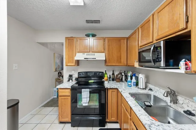 a kitchen with a sink stove top oven and cabinets