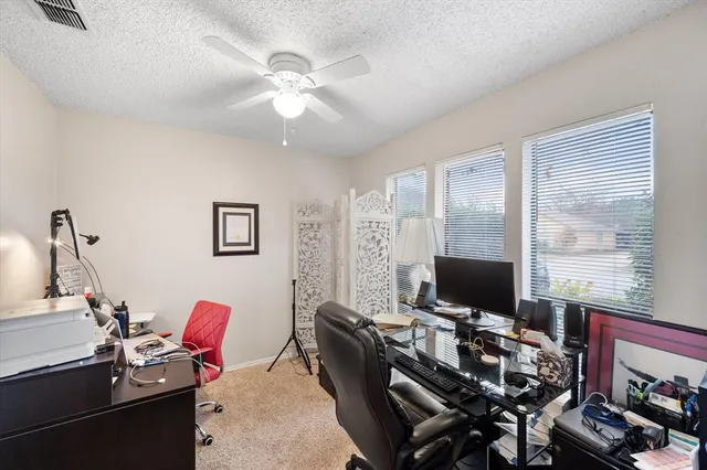 a view of a workspace with furniture and a window