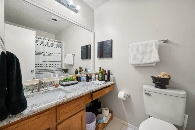 a bathroom with a granite countertop sink mirror vanity and toilet